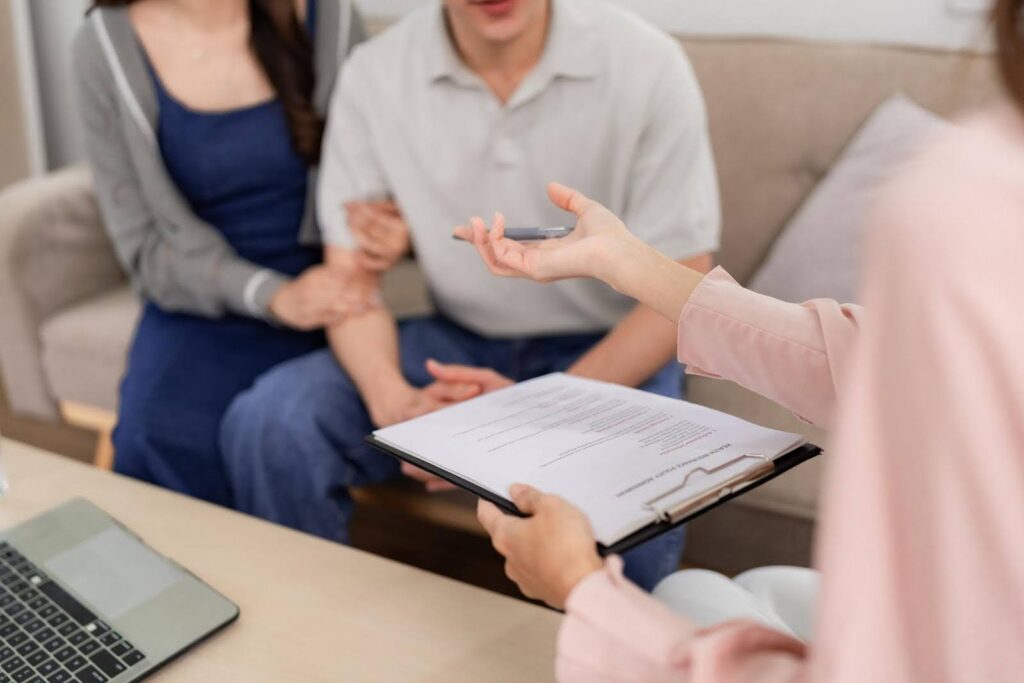 Consultant reviewing documents with clients while discussing a Medicare-Compliant home health policy manual, reflecting CTK Advisors’ expert guidance on achieving full regulatory compliance.