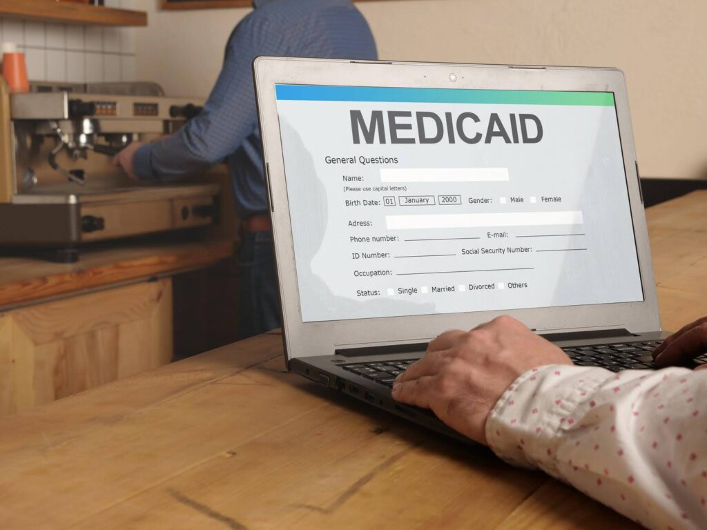 Laptop displaying a Medicaid application form, representing Medicaid waiver programs that require provider licensing, with regulatory guidance from CTK Advisors.