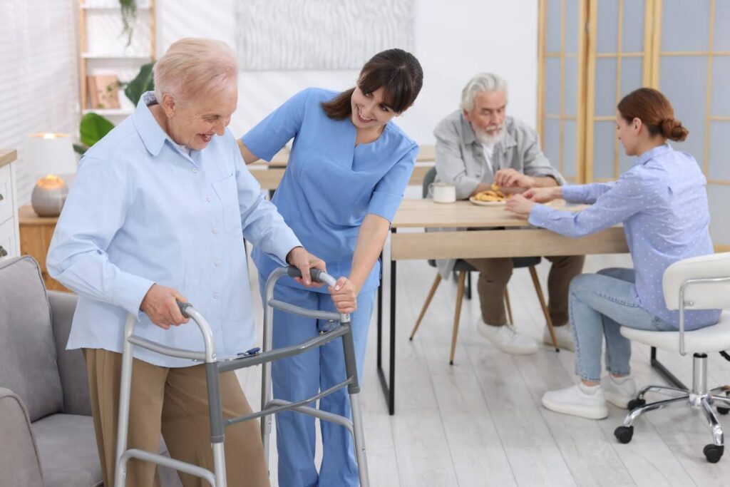 Caregiver assisting a senior with a walker while others receive care in a home setting, representing Ethical considerations in home health care consulting by CTK Advisors.