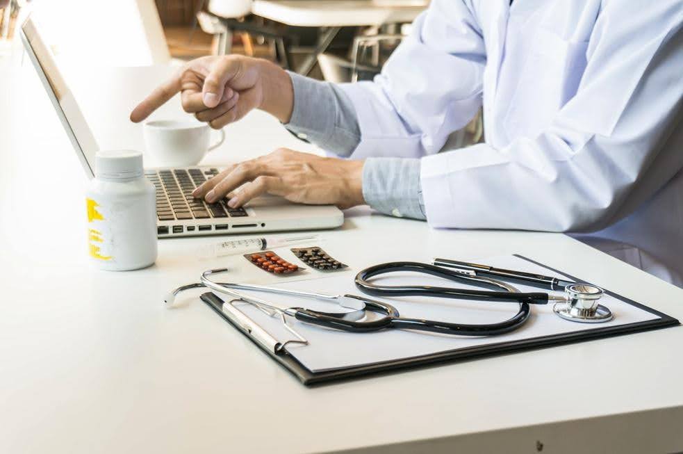 Healthcare professional reviewing business systems on a laptop, highlighting operational challenges as a healthcare business prepares for growth with CTK Advisors.