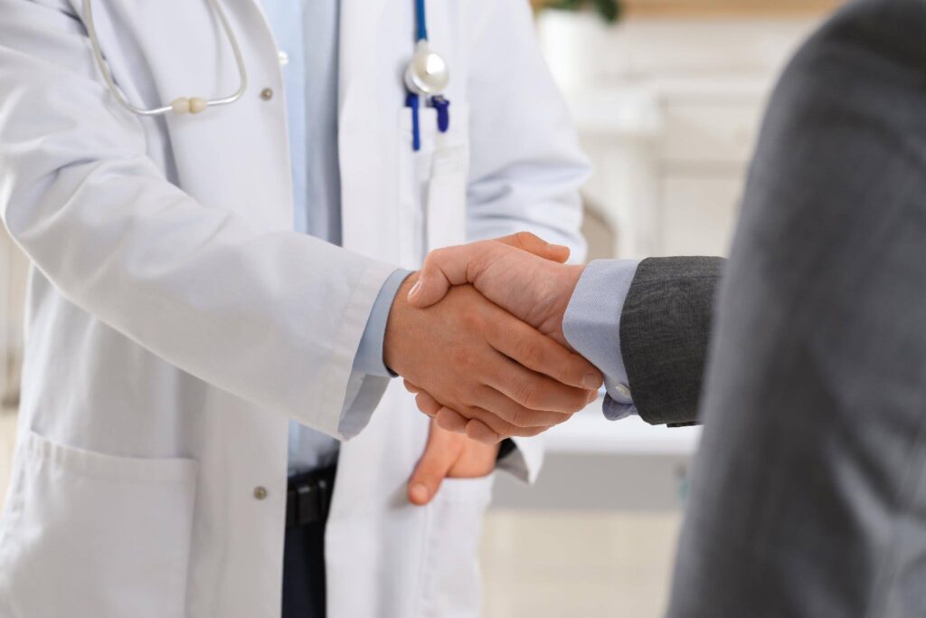 Healthcare professional and business leader shaking hands, representing the operational challenges of rapid healthcare business growth with Ace Home Care.