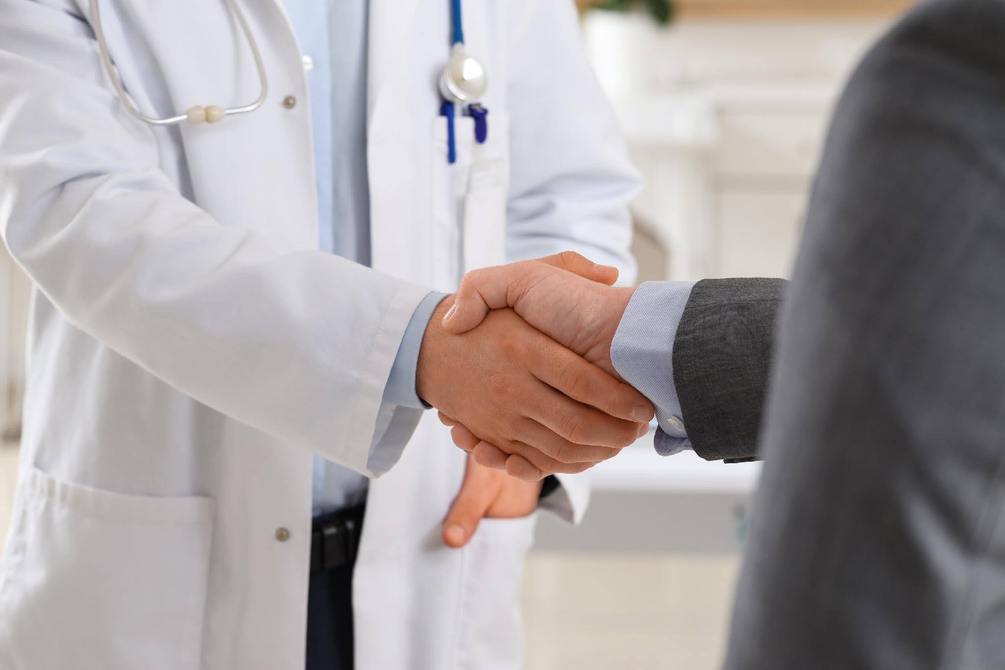Healthcare professional and business leader shaking hands, representing the operational challenges of rapid healthcare business growth with Ace Home Care.