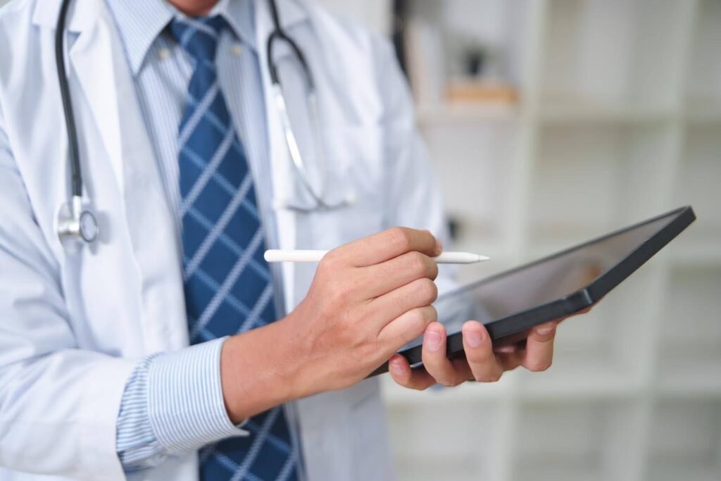 Healthcare professional reviewing digital records on a tablet while preparing for business expansion with CTK Advisors.