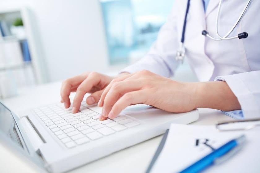 Healthcare professional using a laptop to manage business systems and operations as a healthcare organization prepares for growth with CTK Advisors.