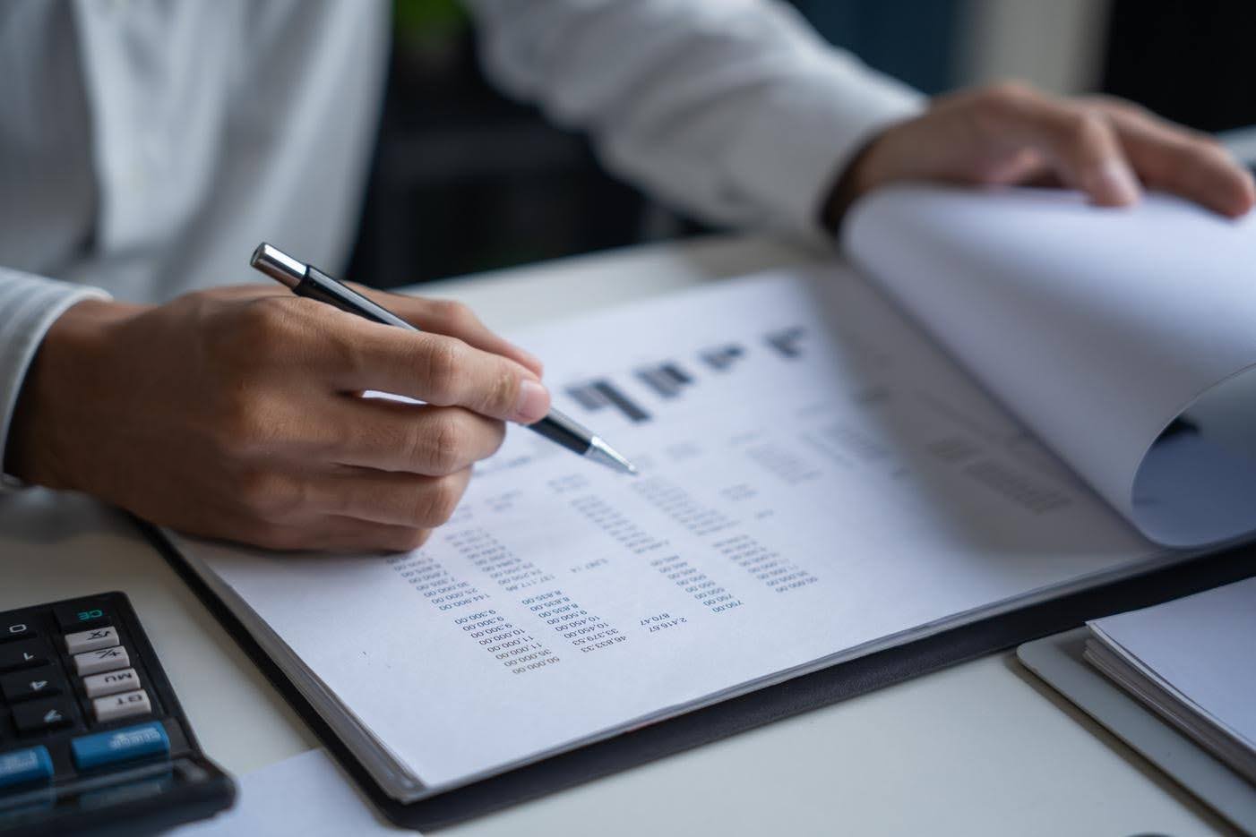 Healthcare business professional reviewing financial reports and compliance documents to maintain regulatory standards after obtaining a license.