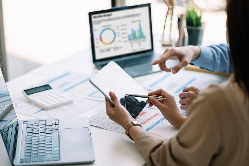 Business professionals reviewing financial reports and performance charts, highlighting the importance of due diligence before acquiring an existing healthcare business.