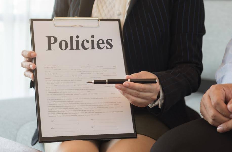 Business professional reviewing Healthcare Policies on a clipboard to assess compliance requirements and identify areas for operational improvement.